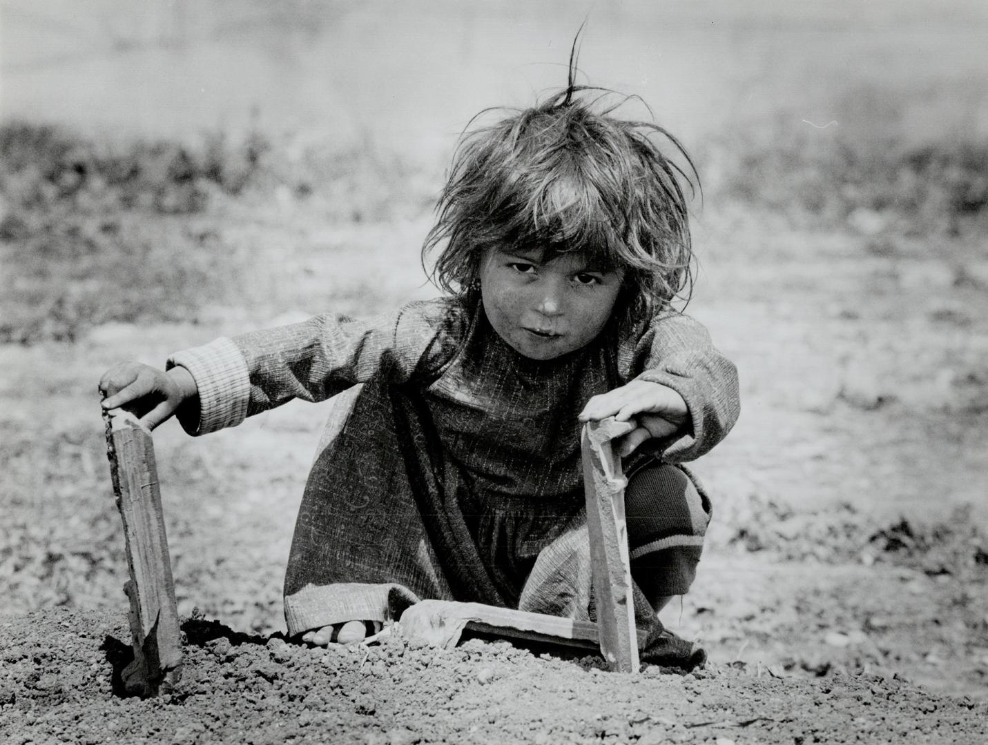 Hard struggle: Clockwise from top, a child uses war debris as toys,