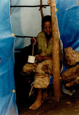 10-year-old drinking banana beer, Mugunga Camp, Zaire