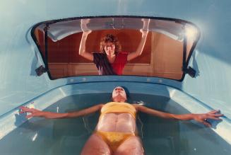Liquid therapy: Julie Trip relaxes in a tank of Epsom salt solution, while Elizabeth Randell gently closes the lid at Tranquility Tanks Ltd