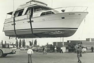 Swiss-bound Canadian beauty, This $ 310,000, 54-foot cruiser floats through the air with the greatest of ease as it's loaded onto another boat, the Mo(...)