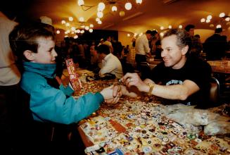 From the thousands of pins available, Tony Kotowich, 7, makes his pick and closes the deal with vendor Gary Wintraub, above