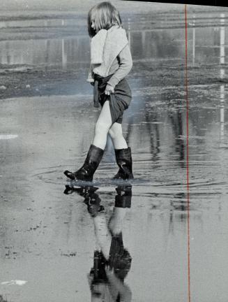 It,s mud puddle weather, It's not yet officially spring, but the weather seems so as Sarah Clark, 7 in rubber wading boots, plods through a king-size (...)