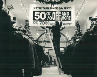 Sign of times: Jack Skupinski posts 70 per cen-off sign at store in the Eaton Centre