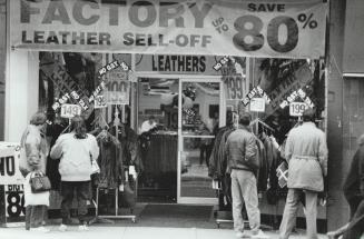 Sale! Sale! Sale! Shoppers check out goods in the window of a downtown leather store yesterday that was offering a no-tax incentive