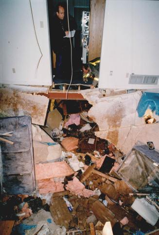 Death Scene: Coroner David Evans examines the hole where a chimney smashed through the floor, killing Elizabeth Mannell