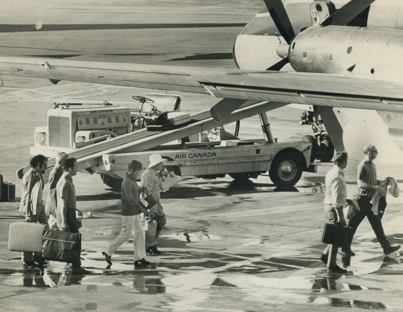 Carrying their own Baggage, passengers head toward a plane at Toronto International Airport today after baggage handlers begana 24-hours strike agains(...)