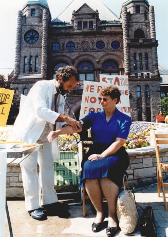 Doctors on strike front of Queens Park group call Central Toronto Position Pix of Dr Alan Kindler checking blood pressure Joan Segee