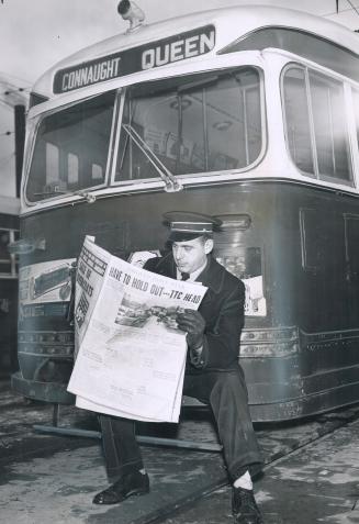 On Picket Duty, TTC Operator George Shaw reads about the strike while sitting on the front of an idled street car