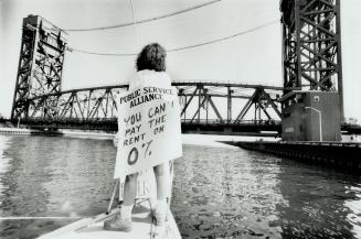 Harbor Closed: A picket looks toward a lift bridge in Hamilton harbor, where striking workers disrupted boat traffic yesterday