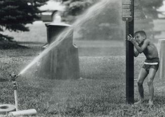 Pole Position, Danny Mahfouz, 7, takes a break after beating the heat, running through the sprinkler at Thomson Memorial Park in Scarborough yesterday(...)