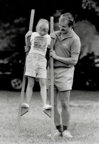 Walking Tall: Holly Gibeau, 7, of Whitby, gets a tip from Scott Mission Fresh Air Camp director Frank Nagy on the art of balancing on stilts