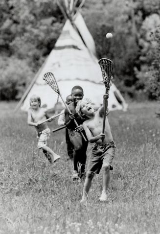 Fun Native-Style: Happy campers (from left) Ryan Garbutt, Fabian and David Francis and Adrian Garbutt play lacrosse at an Indian-style camp