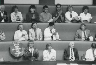 Sombre group: Business people, tenants and homeowners applaud a speaker in the new Metro Hall's council chamber last night
