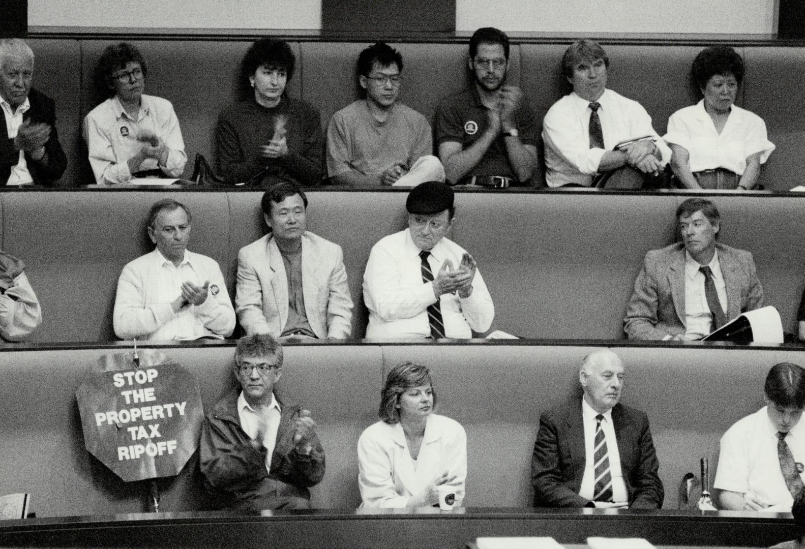 Sombre group: Business people, tenants and homeowners applaud a speaker in the new Metro Hall's council chamber last night