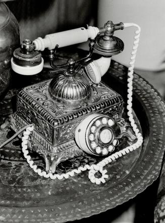 French telephone rests on brass lamp table