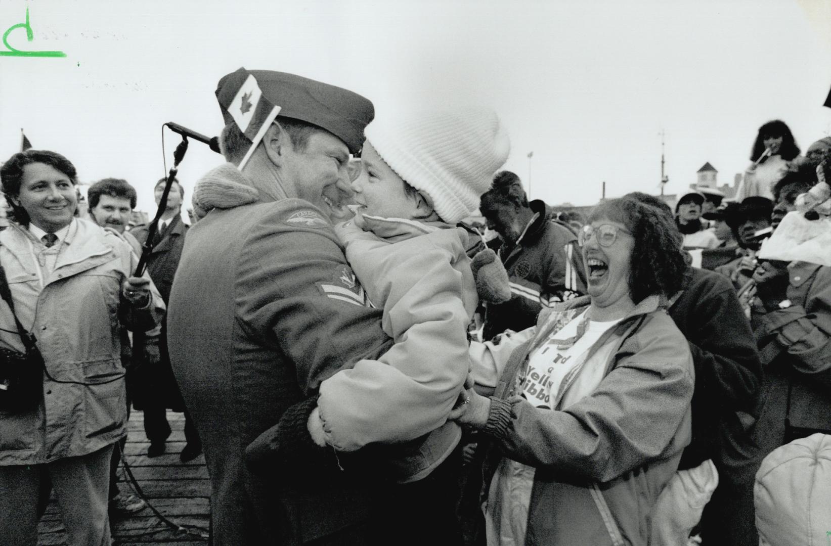 At last: An overjoyed Lynn Davis, above, spots her husband, Harold, among the crowd at Halifax harbor before they have their own family reunion, right