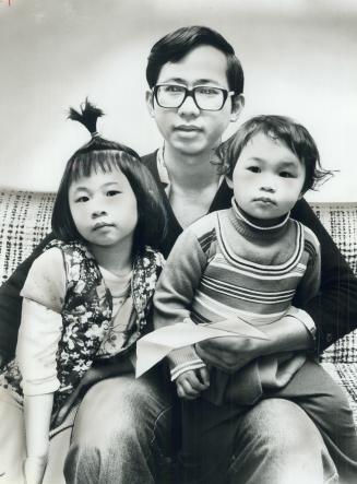 Lu Ming, 35, holds his two daughters, Wing Wai Lui, 4, and Wing Yam Lui, 2