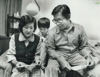 Wu Bang Dam, her husband, Wu Phat, and their son Thai, 11, read smuggled letter