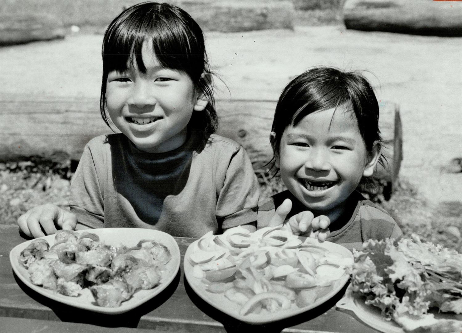 Houat Heng Chim, 8, and Houat Heng Khan, 5, tuck into picnic lunch