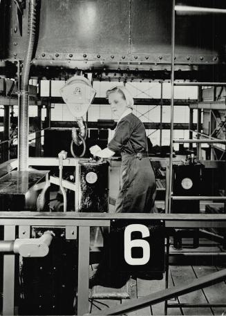 A girl crane operator, Mrs. Blanche Millette, lifts a ten-ton load as easily as she would operate a sewing machine. She is one of thousands praying women have a definite place in ward plants