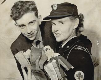 Only survivor of his family, except one cousin who reached Sweden, Leon Chojna, seen with Margaret McPherson, a Red Cross nurse, examines shoes and a (...)