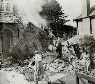 After the raid-residents of a town in Surrey hasten to extinguish a fire in their home, caused by bombs of German raiders in yesterday's a attacks