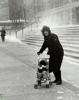 The sting of things to come, A young mother leans into a biting wind on downtown Bay St