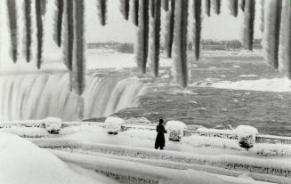 Old man winter puts his stamp on Niagara falls, A solitary visitor is framed by an array of icicles as she looks at the winter wonderland created by t(...)