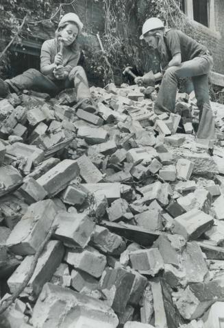 It's all for Women's Lib, say 18-year-old Bev Wooton (left) and 17-year-old Lorrie Wilson as they hammer and chip away at a huge pile of bricks on dem(...)