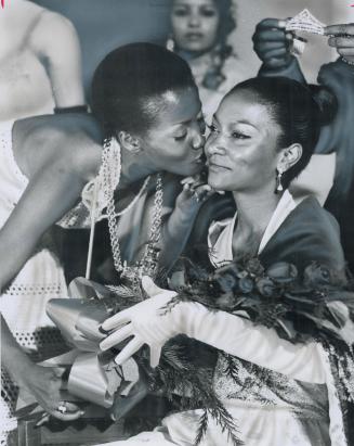 Miss Caribana '71 is crowned, Her crown poised over her head, Miss Caribana '71--Nolan Baynes, 20--is embraced by Liz Philbert (left)