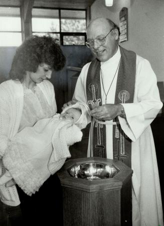 Lutheran leader: Rev. Robert Binhammer, president of the Luthran Church in America - Canada section, baptises Laura Ann, held by her mother Angelika D(...)