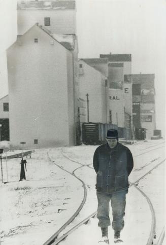 Wheat farmer Joseph Rennick glumly stalks snow-covered railway track running alongside elevators bursting with grain that no one wants to buy. After 3(...)