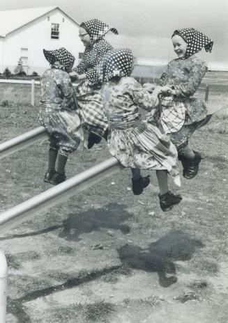 Modern steel teeter-totter, provides amusement for Hutterite girls during recess