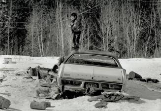 With nothing much to do but hang around, these Moose Lake youngsters amuse themselves playing with an abandoned car