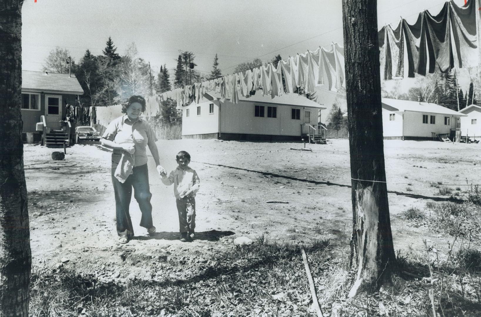 Walking to Shore of Winnipeg river in Minaki, town 40 miles northwest of Kenora, Norma Brant and her son Danny, 3, enjoy spring sun. Mrs. Brant, an In(...)