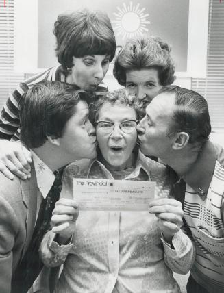 Family shares $1 million, Million-dollar kisses are showered on 68-year-old Dora Soal of Omemee by her family yesterday as she holds cheque for $1 million she won in Provincial Lottery
