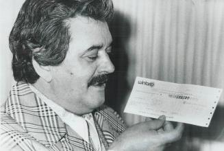 Ottawa chef, Alphonse Lalonde holds cheque for $100,000 he picked up today at the Wintario office in Toronto
