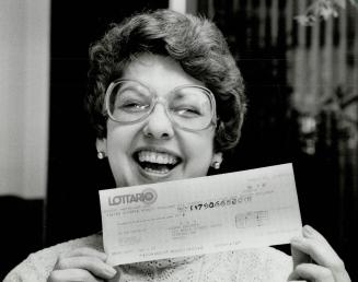 A winning smile: How does it feel to hit Lottario paydirt? Great, says Joan Bozzer of Timmins, displaying her cheque for $790,665, I'm taking the rest of the week off
