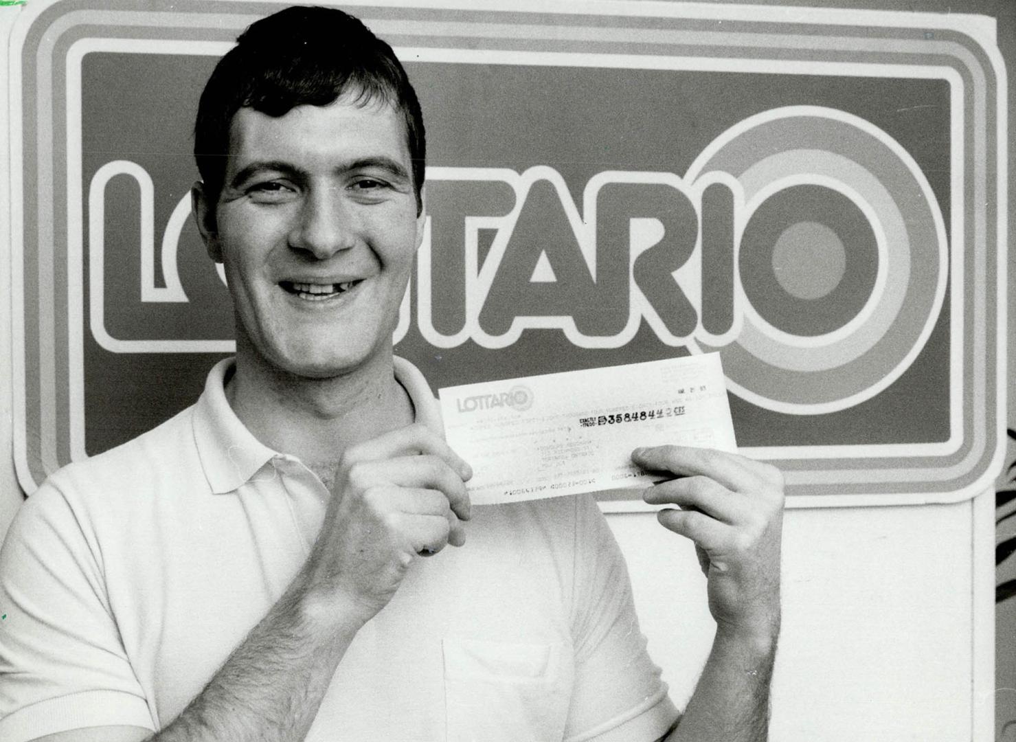 Bachelor wins $358,484 from lottery, Douglas Heughen, 28, laid off from his laborer's job with the City of Toronto, shows the cheque for his winnings (...)