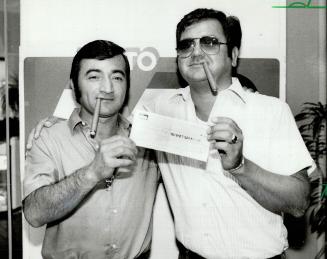 Celebration cigars: Lottery winner Samuel Chica, left, holds a cheque for $273,059 with his brother-in-law Cesar Quezada after he bought five newspapers to be sure he had won