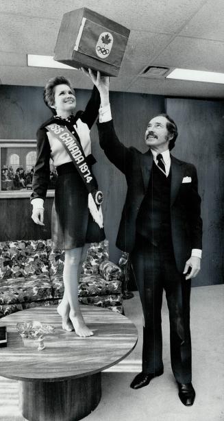 Picking lucky winners, Miss Canada, Blair Lancaster of Burlington, reaches into box held by Olympic Trust president Walter Halder to pick winners of O(...)