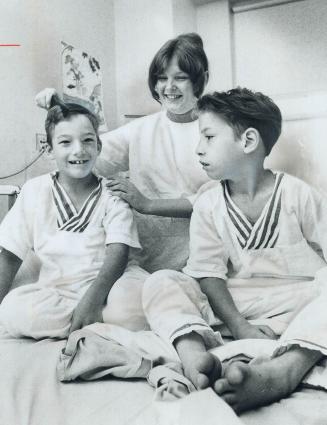 In good spirits, 8-year-old Donald Benoit has his hair combed by nurse Marlene Toon while his 10-year-old brother, Michael, watches. The two boys were(...)