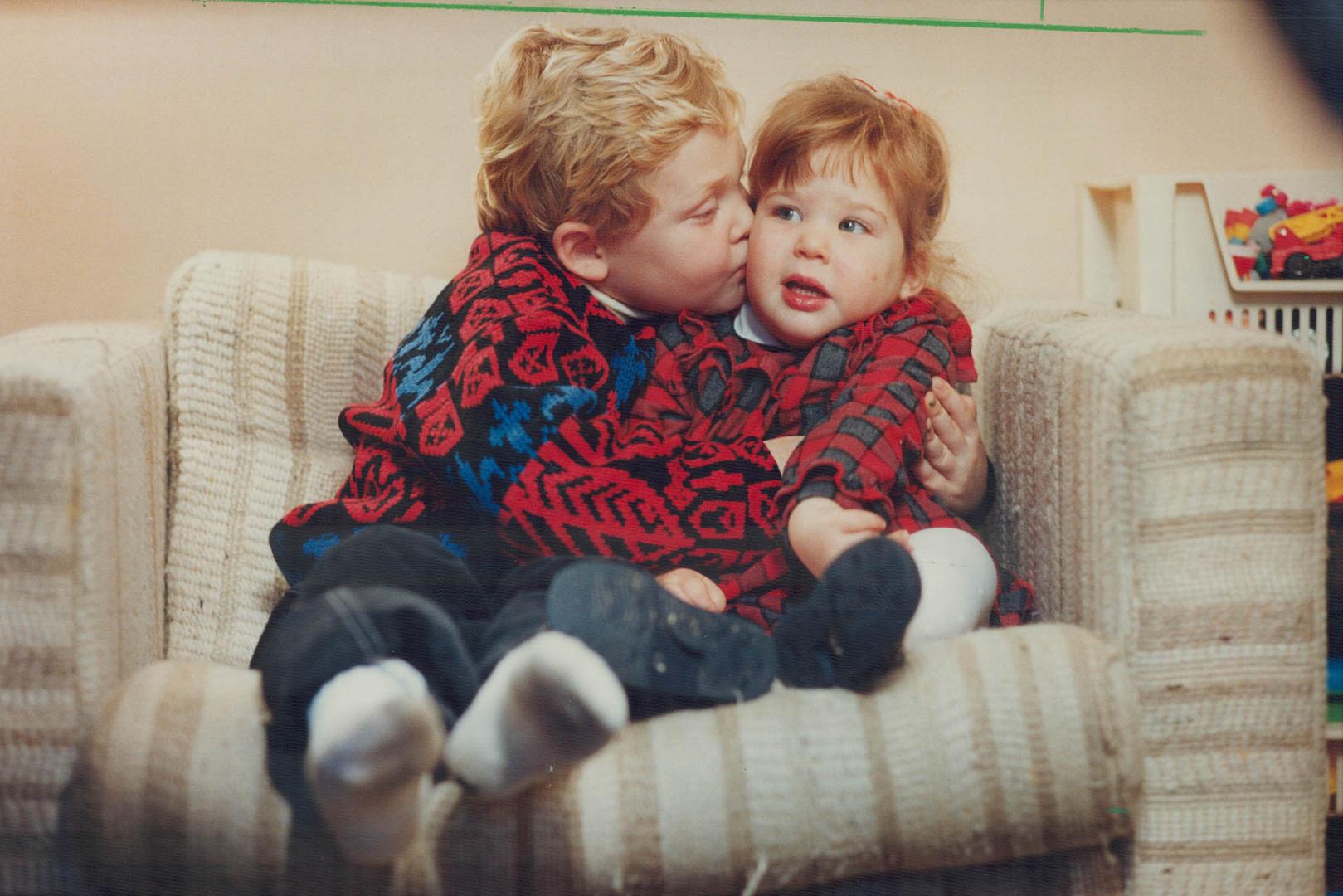 Michael Levine, 4 1/2, gives his sister Stephanie, 2, a hug and a kiss