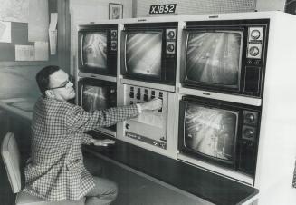 Looking for trouble on the Queen Elizabeth Way, Ken Williams, a ministry of transportation and communications engineer, monitors five TV screens which(...)