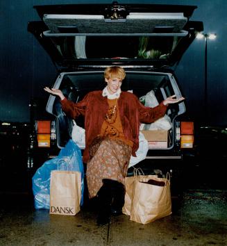 Shopping mania. Lisa Rogers with her purchases, wearing a Harve Bernard fringed suede shirt, $199 U.S. (regular price $340). With it, a sweater, blouse, and print skirt, all from Nilani