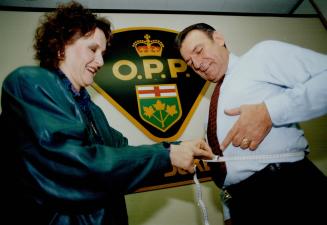 Step One: Linda Shrive of Weight Watchers measures the OPP's Joseph Vertolli as the battle of the (police) bulge begins