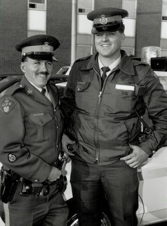 Highway heroes: OPP Constables Dan Jesty, left, and Mike Doucette helped revive a driver who suffered an apparent heart attack on the 401 yesterday