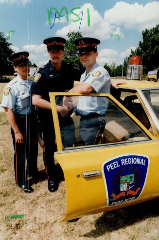 The blue arm of the law, Peel Constable Randy Cowan, centre, tests new uniform