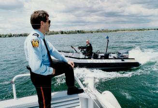 Constable Dave Kennedy pilots the Peel police force'ss 19 1/2-foot zodiac under the watchful eye of Sergeat Mark Crawley
