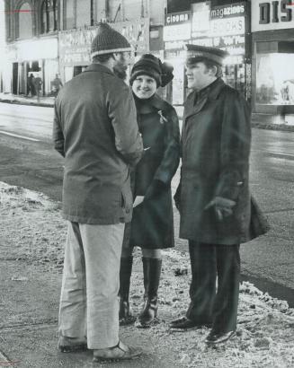 In familiar salvation army uniform, cadets Heather Poole and Brian Page talk to a lone man on the Yonge St
